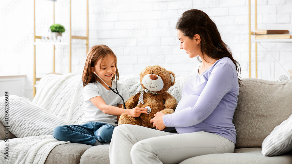 Φωτογραφία Little girl playing doctor with her pregnant young mom, daughter using stethosco