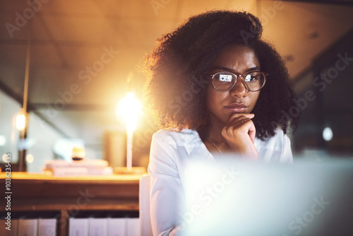 Black woman, thinking and night with laptop or glasses for business decision or project deadline at office. Young African, female person or employee working late in wonder or contemplating choice photo