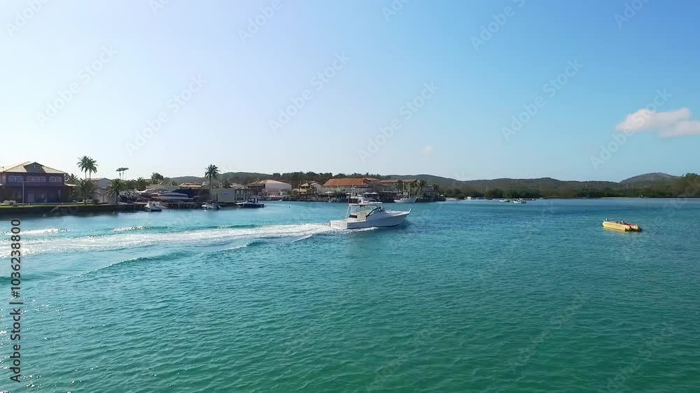 Boat speeding across the clear waters of Itajuru Canal in Cabo Frio, Brazil, on a sunny day. Boat speeding across the clear waters of Itajuru Canal in Cabo Frio, Brazil, on a sunny day.