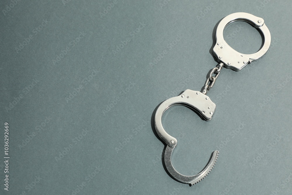 Classic chain handcuffs on grey background, top view. Space for text Classic chain handcuffs on grey background, top view. Space for text