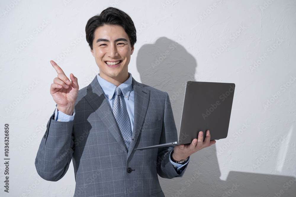 Young businessman posing for point with computer, white background Young businessman posing for point with computer, white background