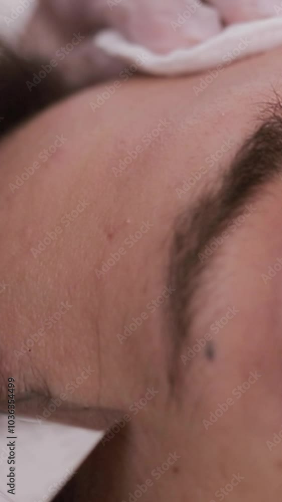 Woman getting tattoo on her eyebrows, enhancing her eye area. Vertical video Woman getting tattoo on her eyebrows, enhancing her eye area. Vertical video