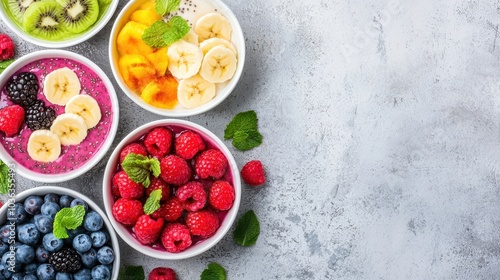 Wallpaper Mural Colorful bowls of fresh fruits and smoothie bowls, including berries, bananas, and mint, arranged on a light gray surface. Torontodigital.ca