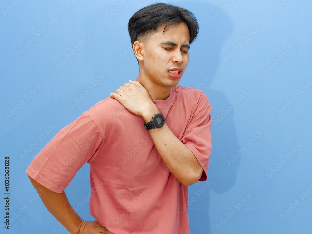 Ταπετσαρία Portrait of an unhealthy young man holding his waist and back with a sad and painful expression on an isolated blue background