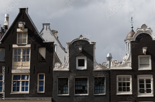 Variety of top floor windows and roofs in building sating tight to each other - 1