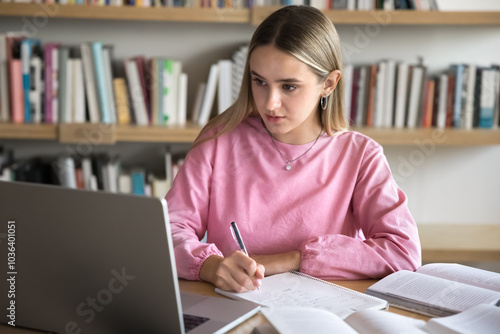 Canvas Print Focused busy intelligent young student girl watching learning webinar on laptop