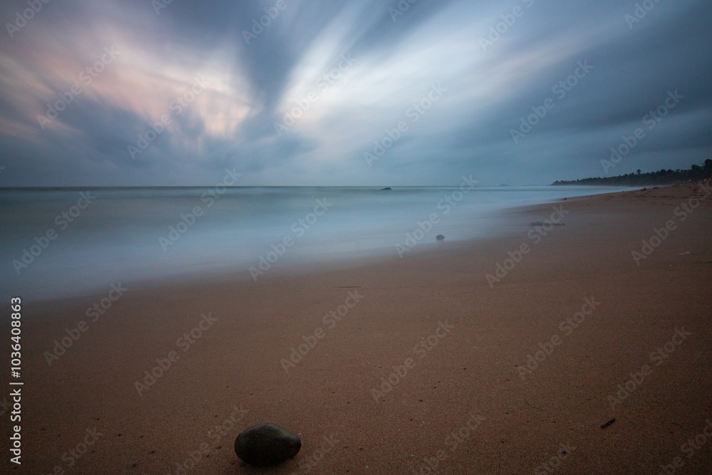 Landscape by the sea. Long deserted beach with water views to the horizon. The waves of a storm break on the sand and give the picture a special touch at sunset. ´ Bentota, Sri Lanka, Asia Landscape by the sea. Long deserted beach with water views to the horizon. The waves of a storm break on the sand and give the picture a special touch at sunset. ´ Bentota, Sri Lanka, Asia