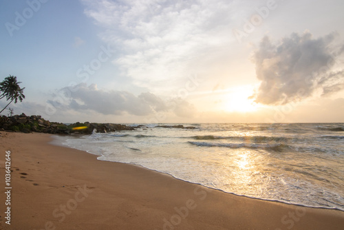 Landscape by the sea. Long deserted beach with water views to the horizon. The waves of a storm break on the sand and give the picture a special touch at sunset. ´ Bentota, Sri Lanka, Asia