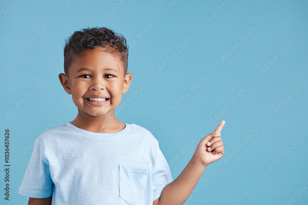 Pointing, space and promotion with portrait of boy in studio for idea, announcement and information. Direction, show and decision with child on blue background for news, presentation and mockup Pointing, space and promotion with portrait of boy in studio for idea, announcement and information. Direction, show and decision with child on blue background for news, presentation and mockup