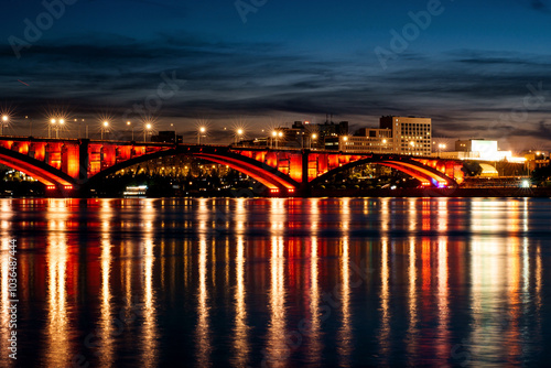 Communal bridge over the Yenisei River at night with beautiful lighting and reflection in the water