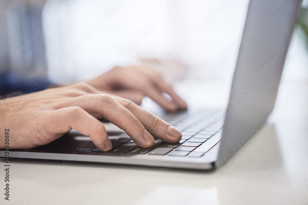 Closeup of male hands typing on modern laptop keyboard on blur office background Closeup of male hands typing on modern laptop keyboard on blur office background