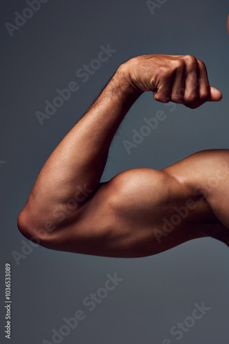Fototapeta Closeup, shirtless and man with muscle, arm and flexing on gray studio background