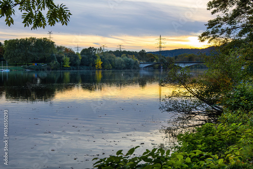 A calm lake with a beautiful sunset in the background