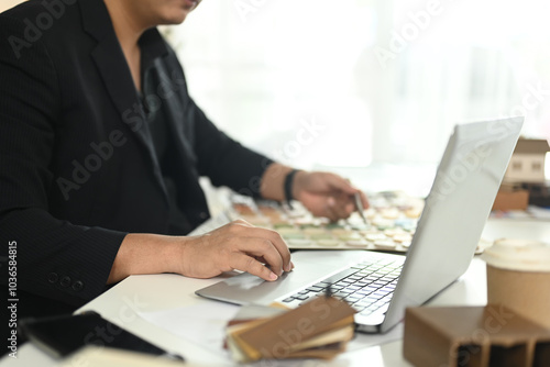 Cropped shot of designer using laptop working on interior renovation at creative office