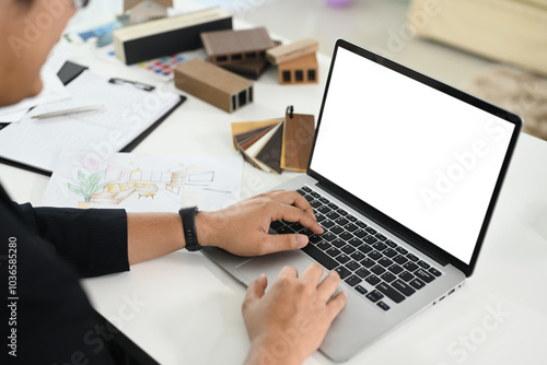 Close up shot of male interior designer using laptop at creative workplace