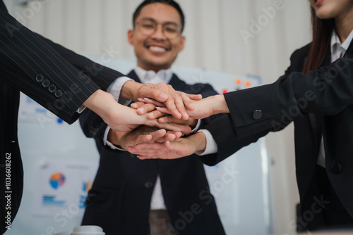 United in Purpose: A diverse team of business professionals stand united, their hands stacked high in a symbol of collaboration, teamwork, and shared goals. photo