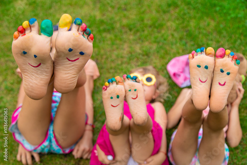 Children's feet painted on the grass. Selective focus.