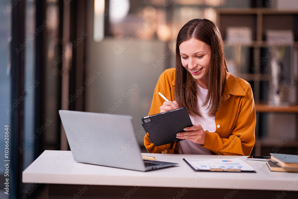 Beautiful professional woman sitting at table smiling while reading important documents with financial graphs and accounting of company. Beautiful professional woman sitting at table smiling while reading important documents with financial graphs and accounting of company.