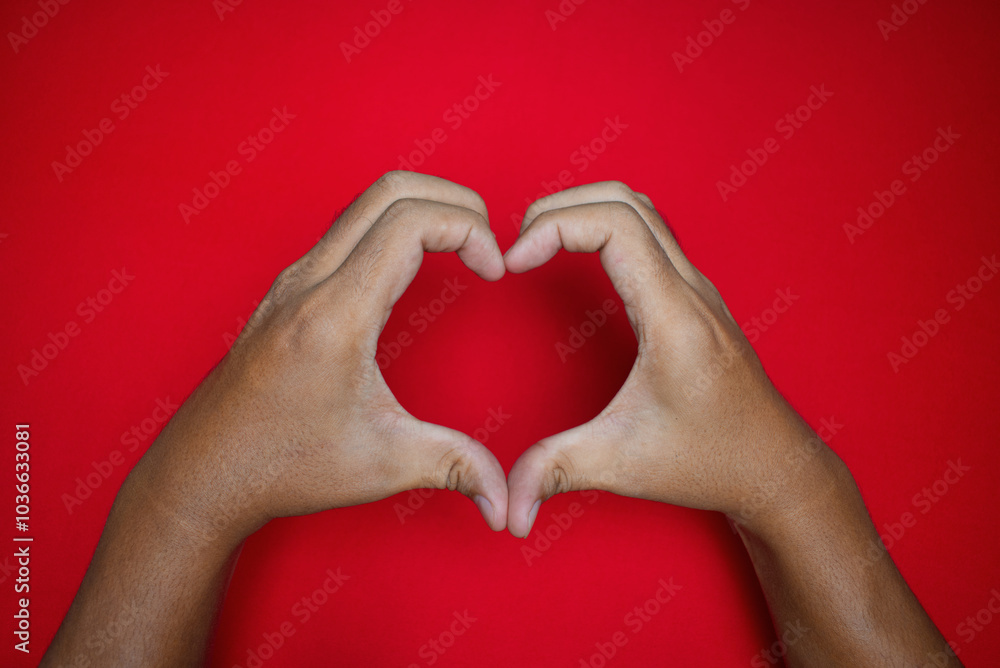 close up of male hands gesturing or making love shape isolated on red background close up of male hands gesturing or making love shape isolated on red background