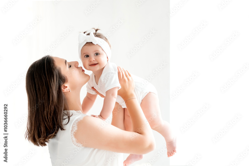 A mother with a small child or infant is playing at home by the window in the children's room. Happy maternity leave, mom's love and care, space for text A mother with a small child or infant is playing at home by the window in the children's room. Happy maternity leave, mom's love and care, space for text