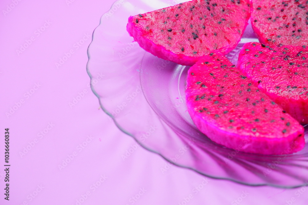 dragon fruit slices on a clear glass plate. dragon fruit slices isolated on a purple background dragon fruit slices on a clear glass plate. dragon fruit slices isolated on a purple background