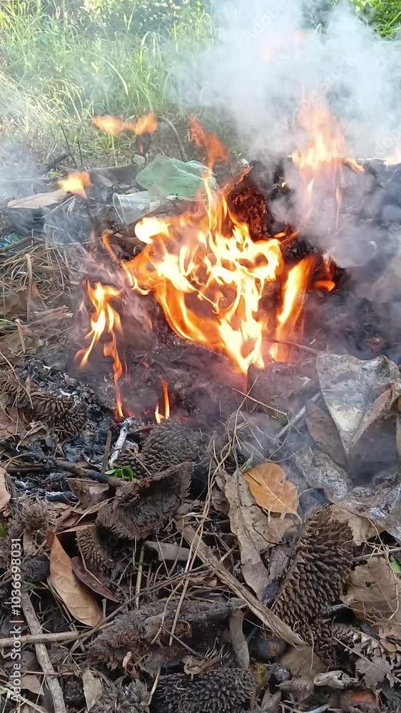 Burning garbage and dry leaves at the garden. Handheld footage. Burning garbage and dry leaves at the garden. Handheld footage.