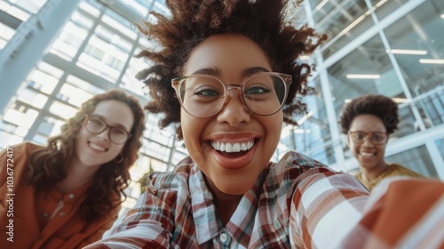 Group of happy young professionals capturing a selfie together at the office, featuring a cheerful businesswoman with her enthusiastic coworkers