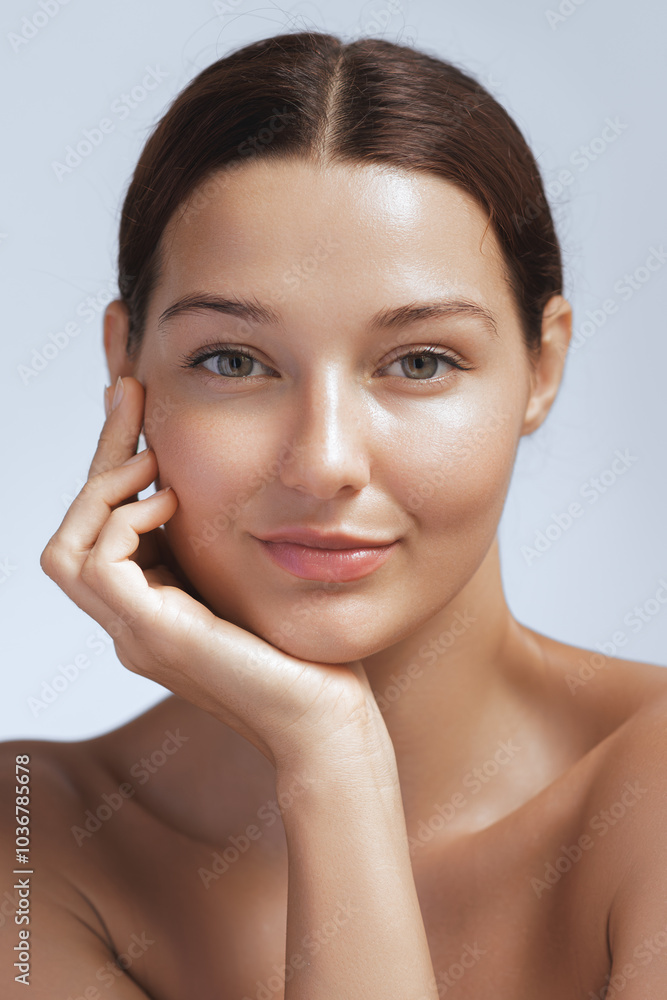 A radiant woman with smooth, flawless skin gently rests her hand on her face, showcasing her natural beauty. Ideal for skincare, beauty, and wellness promotions, highlighting healthy and glowing skin