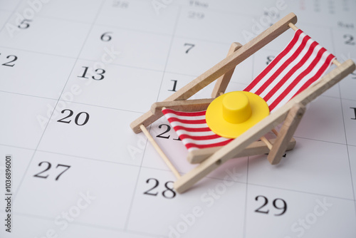 Red beach chair and hat on white blank calendar background copy space. Annual leave travel period for relaxation concept. Period of paid time off (PTO) granted to employees by their employer.