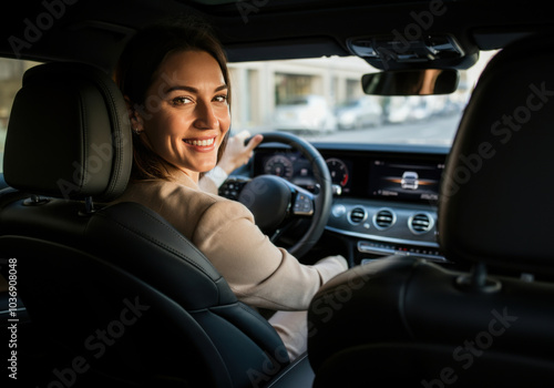 Smiling woman driving a luxury car in the city during the day, showcasing joy and confidence behind the wheel