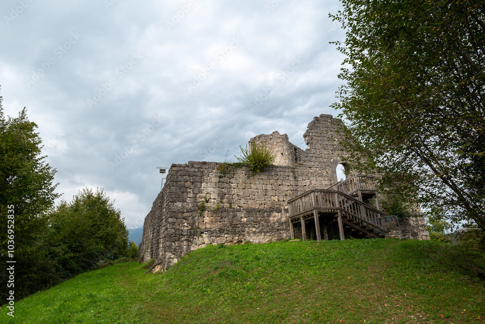 The medieval castle of Solimbergo, fraction of Sequals in Friuli, at the top of a hill that you can reach hiking in autumn. We see a wooden staircase with its ledge and over us a dramatic cloudy sky. The medieval castle of Solimbergo, fraction of Sequals in Friuli, at the top of a hill that you can reach hiking in autumn. We see a wooden staircase with its ledge and over us a dramatic cloudy sky.