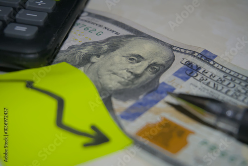 A close-up of Benjamin Franklin on a U.S. dollar bill, partially covered by bright sticky notes featuring dollar symbols and a upward arrow, symbolizing financial trends and economic changes.
 photo