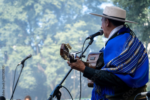 Photos Gaucho argentino con sombrero y poncho azul tocando la guitarra y cantando folkl