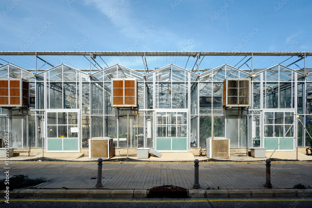 Obraz premium Modern Industrial Greenhouse Exterior with Air Conditioning Units under a Clear Blue Sky