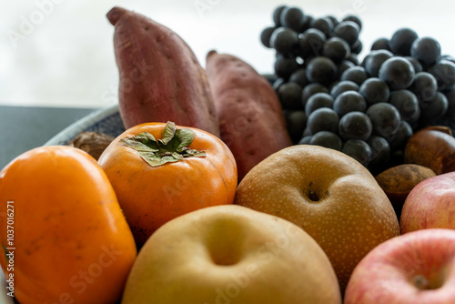 籠に入った秋の味覚：柿・林檎・梨・葡萄・薩摩芋