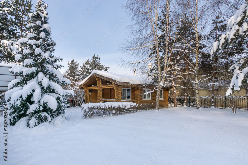 A wonderful winter landscape with a wooden log house surrounded by snow-covered fir .trees in the rays of the setting sun. A wonderful winter landscape with a wooden log house surrounded by snow-covered fir .trees in the rays of the setting sun.