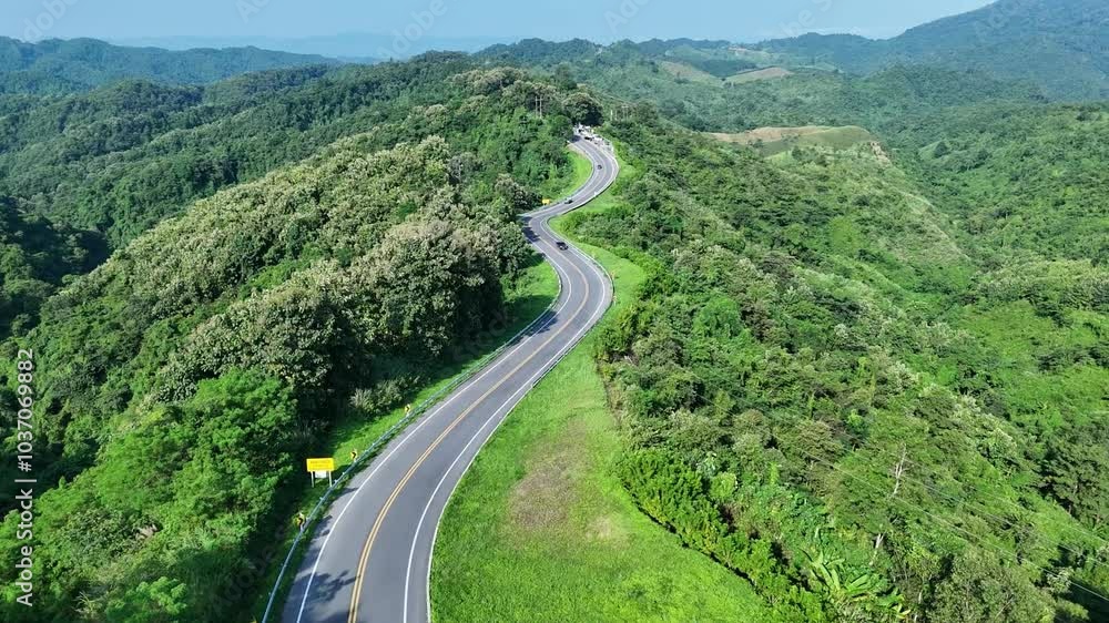 Aerial view highway Drone flying above winding road during sunlight, Winding asphalt road through tropical rainforest. countryside landscape. Landmark tourist attractions in Nan Province, Thailand.
Aerial view highway Drone flying above winding road during sunlight, Winding asphalt road through tropical rainforest. countryside landscape. Landmark tourist attractions in Nan Province, Thailand.