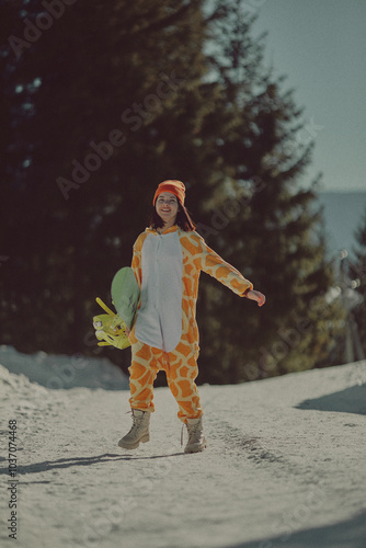  A girl with a snowboard in her hands against the backdrop of snowy mountains