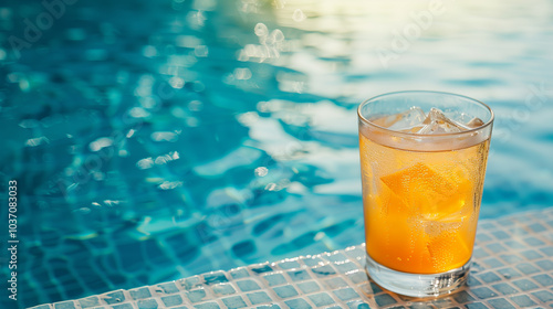 close up orange Drink with ice next to the pool background