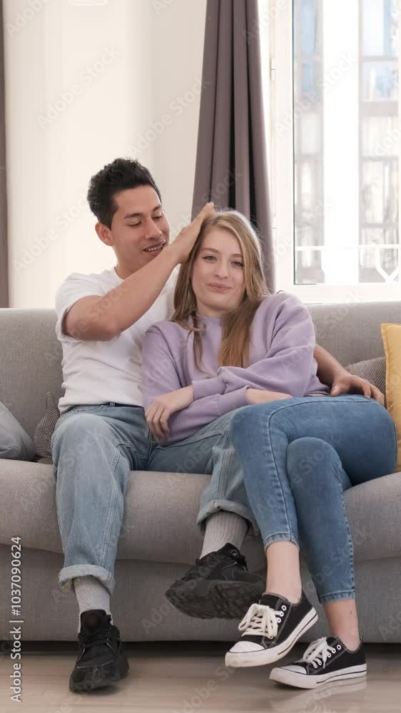Young couple joyfully posing together on a comfortable sofa in their living room Young couple joyfully posing together on a comfortable sofa in their living room