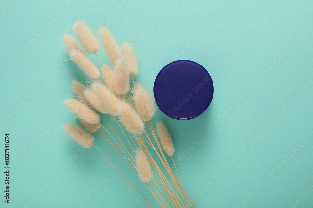 Night cream jar with lagurus flower on mint green background. Top view Night cream jar with lagurus flower on mint green background. Top view