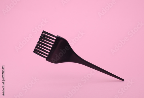 Hair dye brush floting on pink background photo