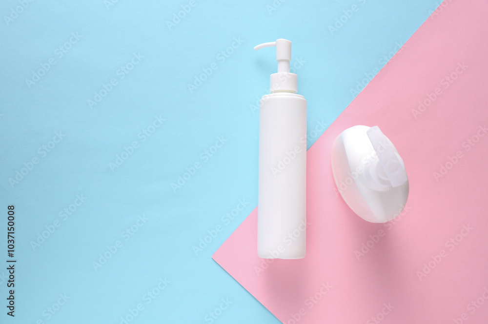 Liquid soap or shampoo bottles with dispensers on blue pink background Liquid soap or shampoo bottles with dispensers on blue pink background