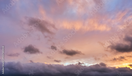 A beautiful sky tinted by the sun leaving vibrant shades of gold, pink, blue and multicolored. Clouds in the twilight evening and morning sky. Cloudy sky background in the evening, and during the day.