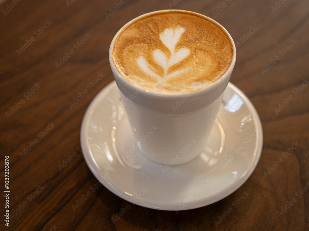 Delicious coffee with milk in white cup on a brown textured table, closeup. Delicious coffee with milk in white cup on a brown textured table, closeup.