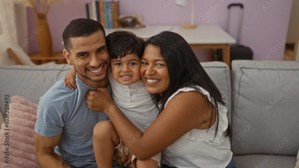 Happy family at home featuring a man, woman, and child sitting together on a couch in a cozy living room Happy family at home featuring a man, woman, and child sitting together on a couch in a cozy living room
