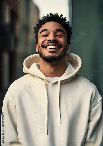 A happy mixed race british man wear cream hoodie sweatshirt laughing adult.