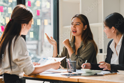 Engaged women discussing ideas in modern office setting, showcasing collaboration and creativity. Their expressions reflect enthusiasm and teamwork