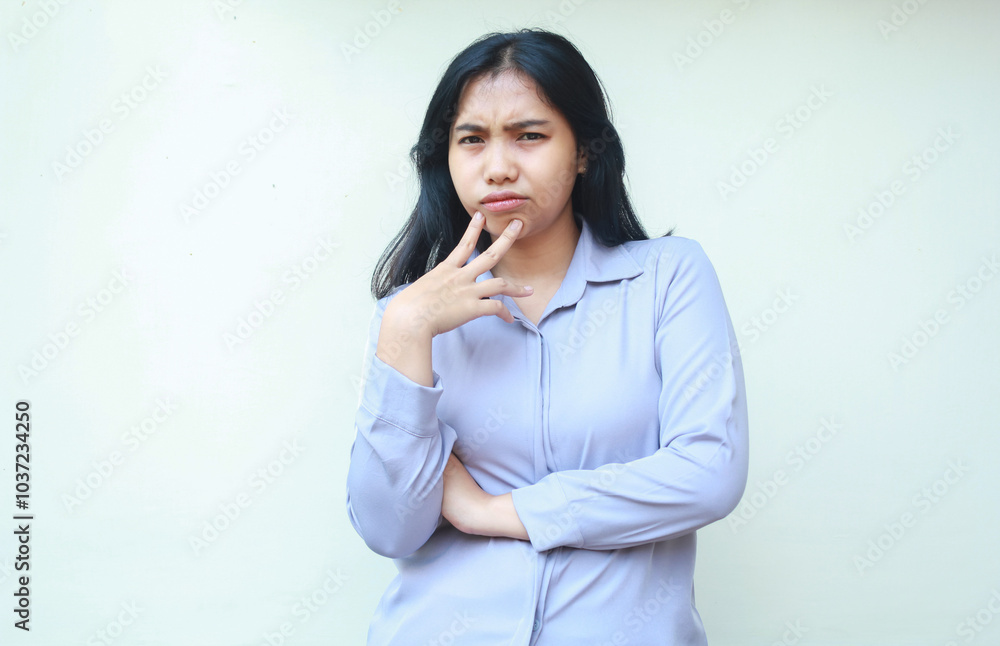 thoughful serious asian young woman employee looking to camera suspiciously with folded arm and touching chin isolated on white background thoughful serious asian young woman employee looking to camera suspiciously with folded arm and touching chin isolated on white background
