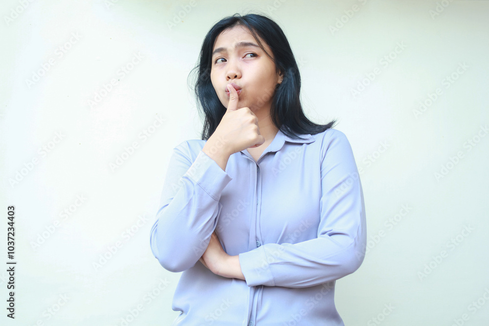 beautiful pensive asian woman daydreaming looking away woth thumbs up kiss by lips with arm folded wear formal suit isolated by white background beautiful pensive asian woman daydreaming looking away woth thumbs up kiss by lips with arm folded wear formal suit isolated by white background